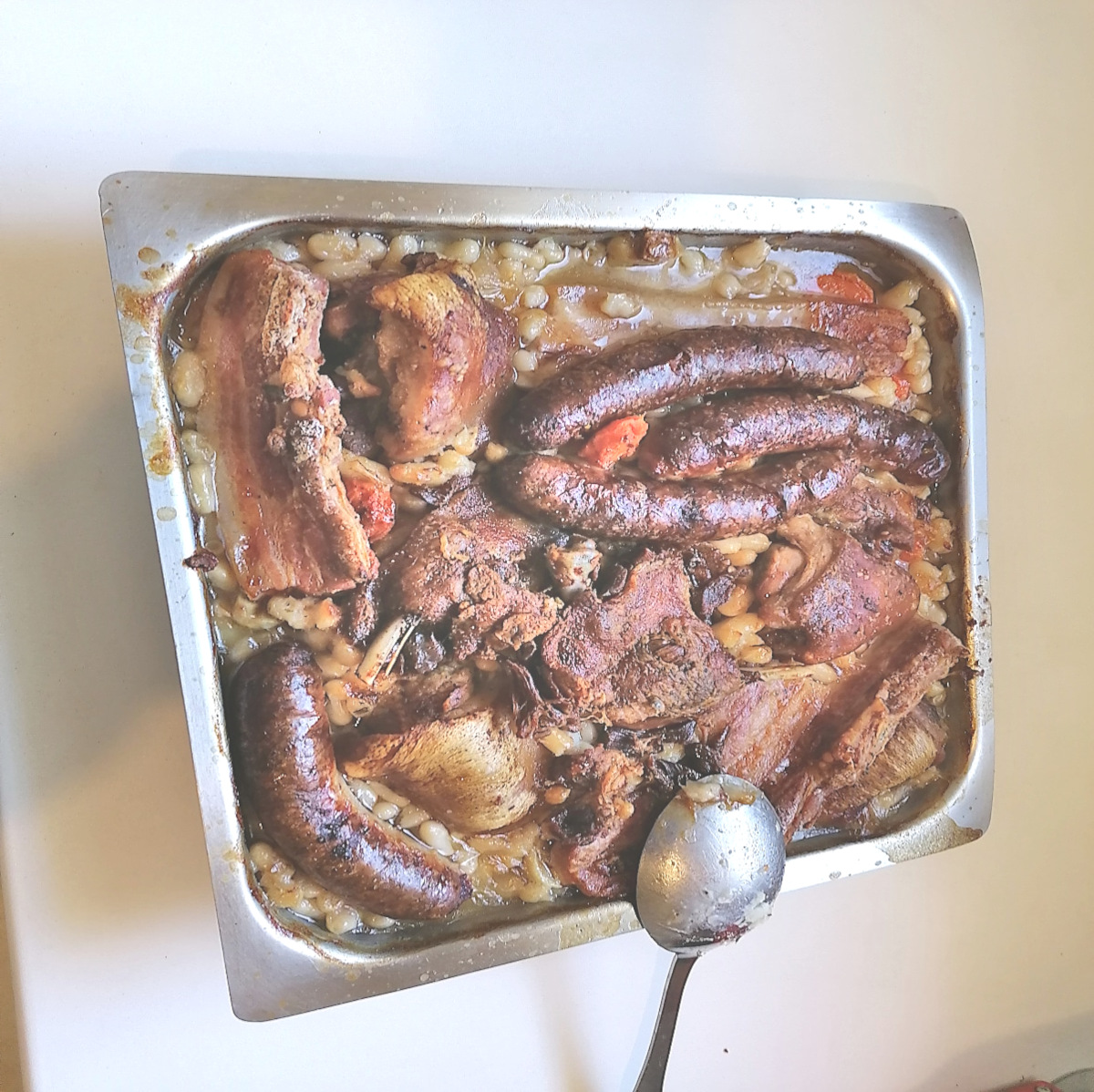 Cassoulet maison traditionnel dans une cassole avec haricots blancs et saucisse