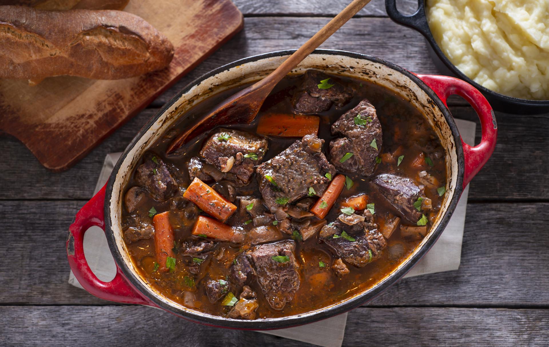 Civet de sanglier mijoté dans une cocotte en fonte avec carottes et vin rouge